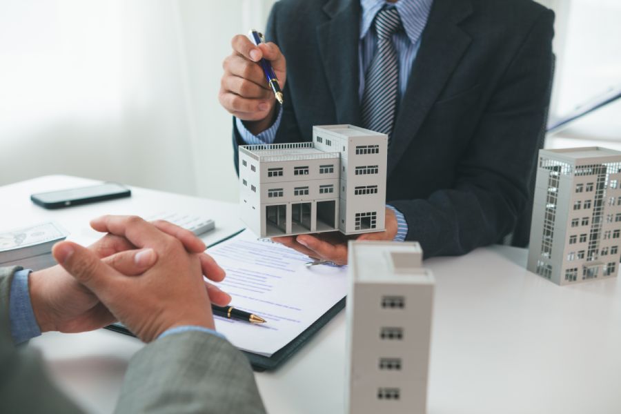 Mężczyzna wybiera między modelami domów, porównując raty od dewelopera i zakupy na rynku wtórnym w Bułgarii.